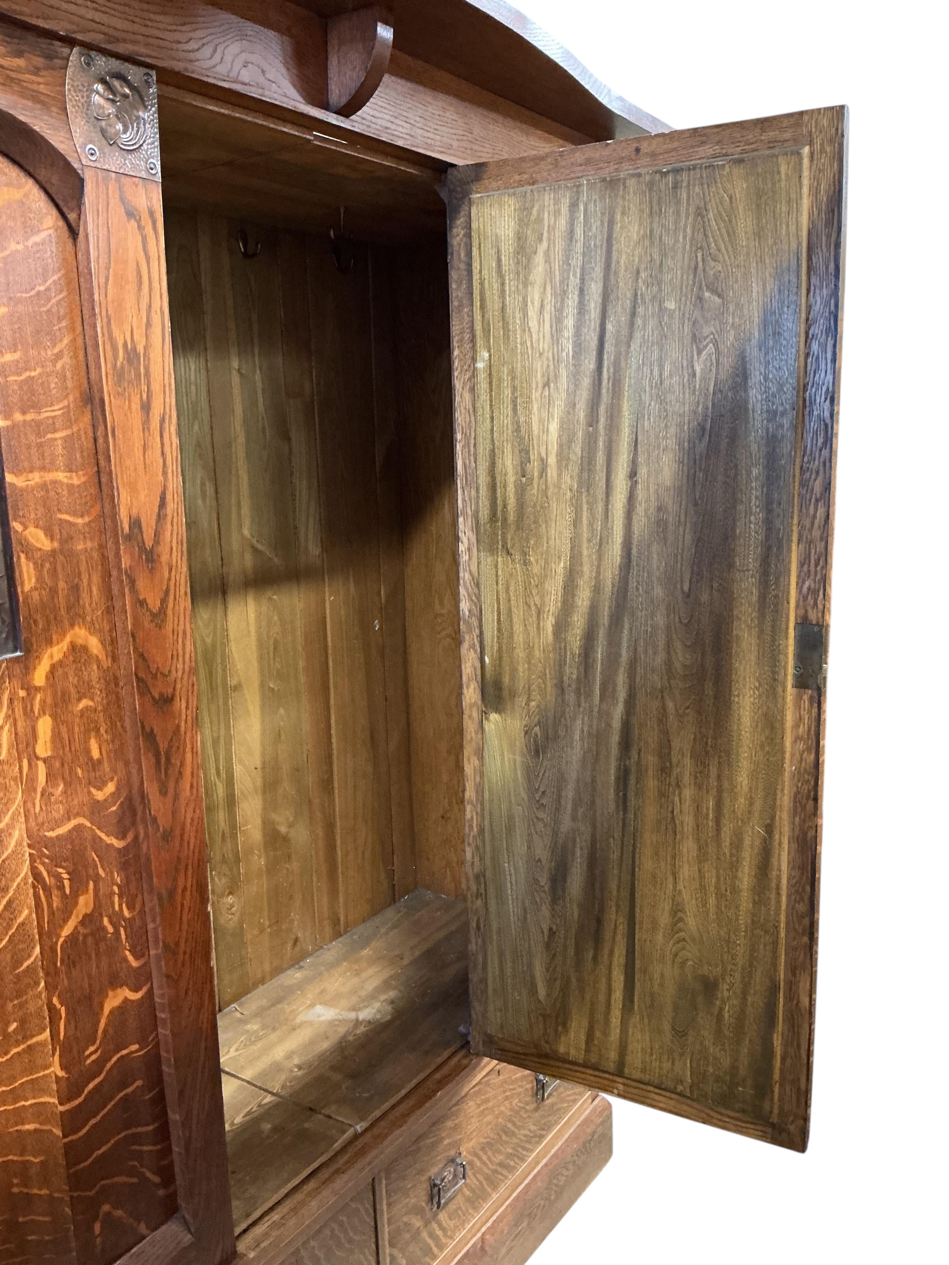 An Arts and Crafts copper mounted oak wardrobe in the manner of Shapland & Petter, width 176cm, depth 65cm, height 209cm